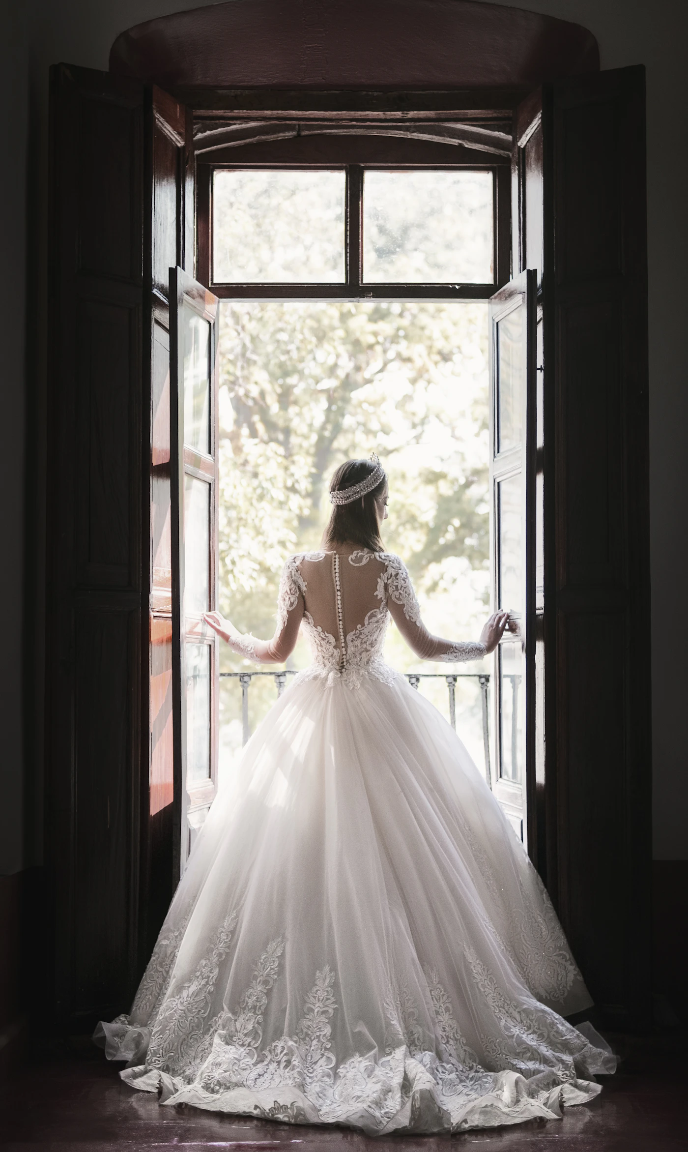 Mireasă în rochie albă lângă fereastră